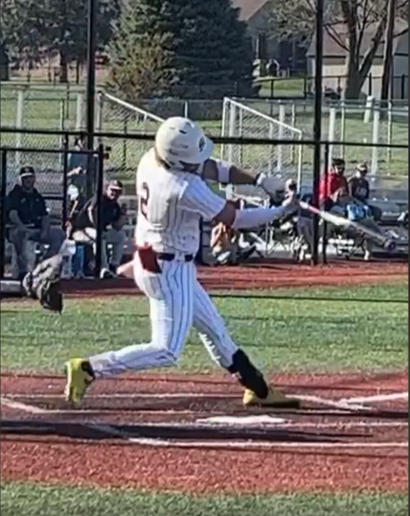 Baseball hitter in follow-through at home plate