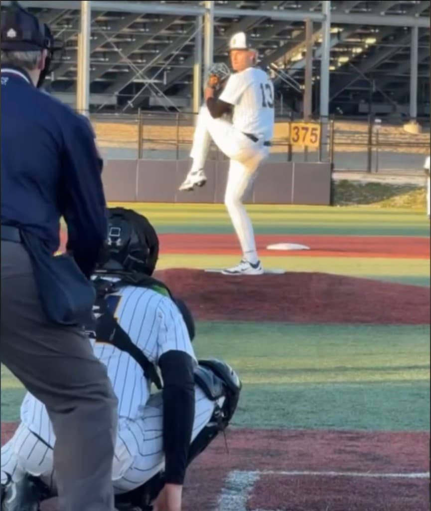 Pitcher delivering a pitch with catcher behind home plate
